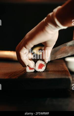 Nahaufnahme, Sushi mit Lachs auf einem in Stücke geschnittenen Holzbrett Stockfoto