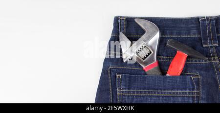 Mehrere Werkzeuge in der hinteren Denim-Tasche. Instrumente in der Gesäßtasche. Platz für Ihren Text Stockfoto