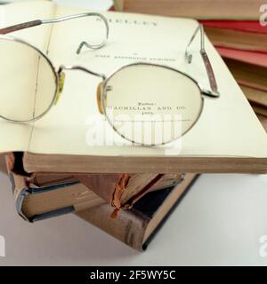 Seltene alte Vintage-Bücher aus der Bibliothek Shelley Gedichte, oben auf einer alten Brille auf weißem Hintergrund Stockfoto