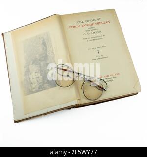 Black & White Seltene alte Vintage-Bücher aus der Bibliothek Shelley Gedichte, oben auf einer alten Brille auf weißem Hintergrund Stockfoto
