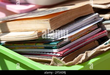 Viele verschiedene alte Bücher und Papier-Notizbücher in einem Container draußen in Sonnenlicht, Stapel. Box voller alter Literatur, verlosen gebrauchte Bücher. Buch fa Stockfoto