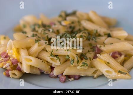 Pasta mit Schinken und Eiern auf einem Teller Stockfoto