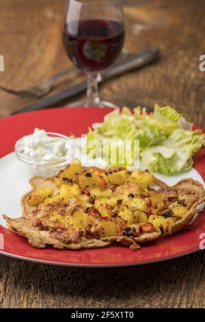 österreichischer Pfannkuchen mit Kartoffeln und Salat Stockfoto