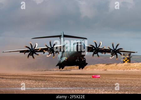 CEFN SIDAN, WALES - MÄRZ 25 2021: Ein Royal Air Force Airbus A400M 'Atlas' Militärtransportflugzeug übt taktische Landungen an einem Strand aus Stockfoto
