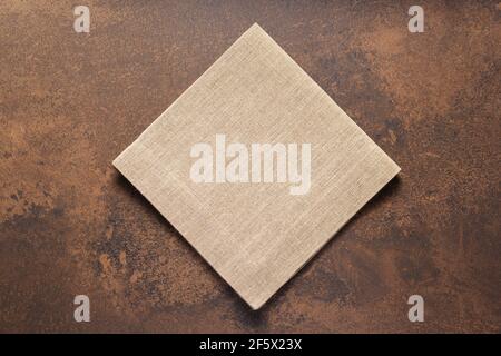 Gefaltete Etuischuh Leinen Tischdecke auf Stein Oberfläche des Tisches. Hessischer Sack Serviette Textur Hintergrund. Draufsicht Stockfoto