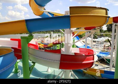 Bunte Plastikrutschen im Aquapark. Teil des Wasserparks - ein Rutschelement aus blau, gelb, rot, weiß. Dnipro Stadt, Ukraine. Dnepropetrowsk Stockfoto