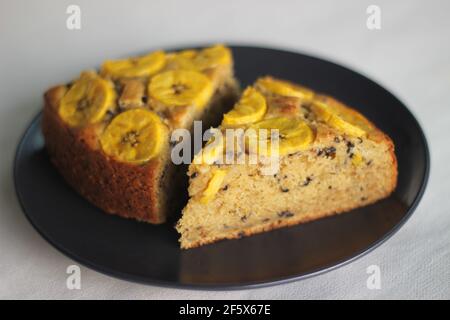 Scheiben von hausgemachtem Kochbananen-Kuchen mit Kochbananen als Belag. Aufgenommen auf weißem Hintergrund. Stockfoto