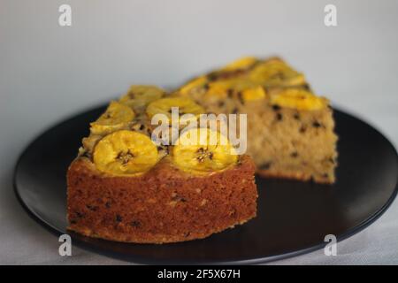 Scheiben von hausgemachtem Kochbananen-Kuchen mit Kochbananen als Belag. Aufgenommen auf weißem Hintergrund. Stockfoto