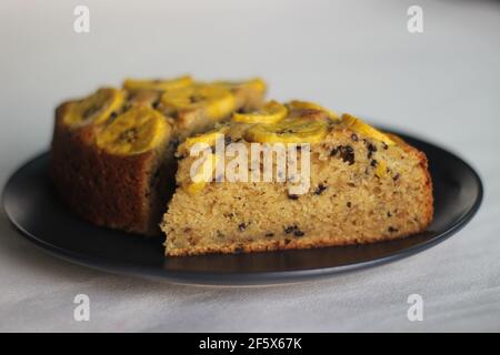 Scheiben von hausgemachtem Kochbananen-Kuchen mit Kochbananen als Belag. Aufgenommen auf weißem Hintergrund. Stockfoto