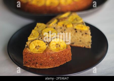 Scheiben von hausgemachtem Kochbananen-Kuchen mit Kochbananen als Belag. Aufgenommen auf weißem Hintergrund. Stockfoto