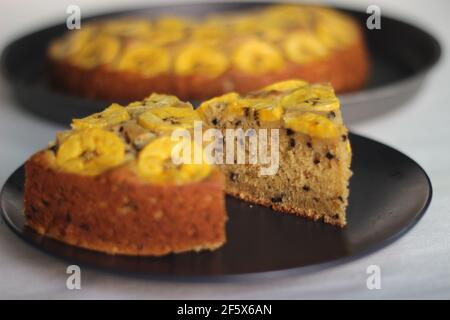 Scheiben von hausgemachtem Kochbananen-Kuchen mit Kochbananen als Belag. Aufgenommen auf weißem Hintergrund. Stockfoto