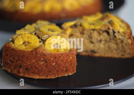 Scheiben von hausgemachtem Kochbananen-Kuchen mit Kochbananen als Belag. Aufgenommen auf weißem Hintergrund. Stockfoto