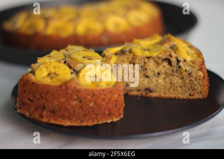 Scheiben von hausgemachtem Kochbananen-Kuchen mit Kochbananen als Belag. Aufgenommen auf weißem Hintergrund. Stockfoto