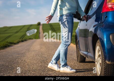 Unverantwortlicher Fahrer wirft Wasserflasche auf der Straße. Konzept der Kunststoffverschmutzung. Umweltschutz Stockfoto