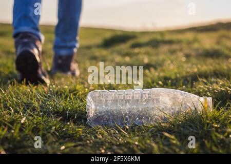 Verschmutzen Sie die Natur nicht mit Plastikmüll! Wasserflasche in der Natur. Tourist verlassen Plastikflasche im Gras Stockfoto