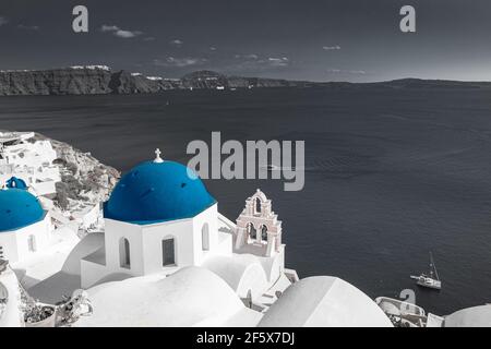 Selektives Farbbild, blaue Farbe mit Schwarzweiß-Verfahren. Oia Blick auf Santorini, Caldera und blaue Kirche Kuppel. Idyllische, inspirierende Reise Stockfoto