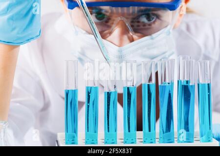 Forscherin nutzt Micropipette-Abfüllsteströhrchen.EINE Laborantin in einem Labor mit Reagenzgläsern produziert Impfstoffproben. Entwicklung Stockfoto