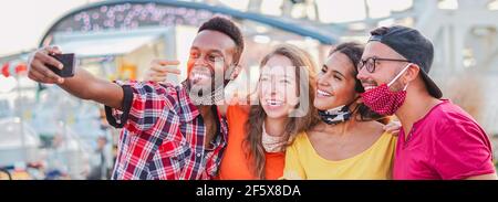 Multirassische Freunde nehmen Selfie mit Gesichtsmaske in Coronavirus Zeit - Junge Menschen Spaß im Urlaub - neues Lifestyle-Konzept Stockfoto