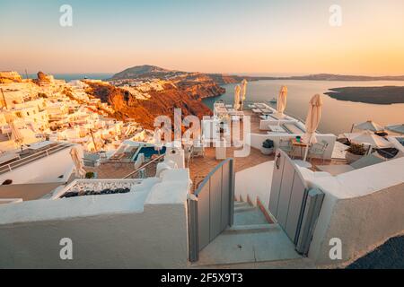 Wunderschöner Sonnenuntergang auf Santorini, Griechenland. Stühle auf der Terrasse mit Meerblick. Konzept für Reiseziele. Sommerurlaub Landschaft Stockfoto