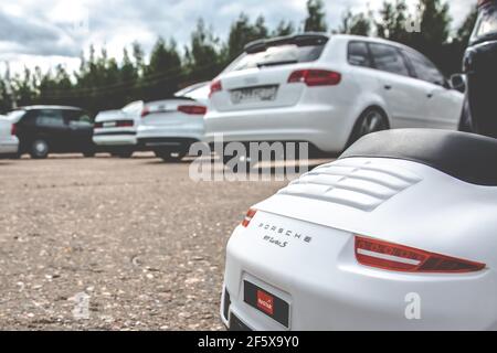 Moskau, Russland - 06. Juli 2019: Spielzeugauto Porsche 911 Carrera Turbo S auf dem Parkplatz mit echten Autos. Heckteil des Fahrzeugs Stockfoto