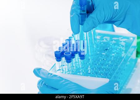 Forscherin nutzt Micropipette-Abfüllsteströhrchen.EINE Laborantin in einem Labor mit Reagenzgläsern produziert Impfstoffproben. Entwicklung Stockfoto