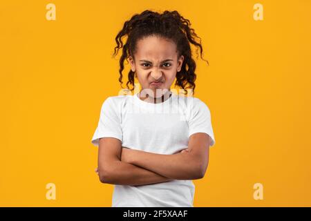 Beleidigt junge schwarze Mädchen stehen mit gefalteten Armen Stockfoto