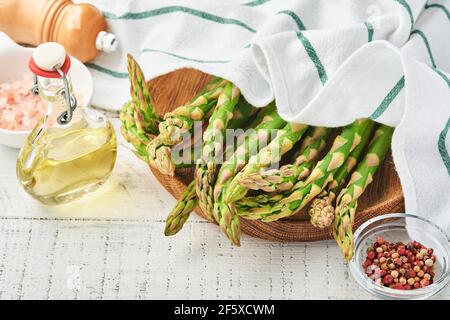 Spargel. Frische grüne Spargelbündel bereit zum Kochen auf weißem alten hölzernen Hintergrund. Kopiespeicherplatz in der Draufsicht. Stockfoto