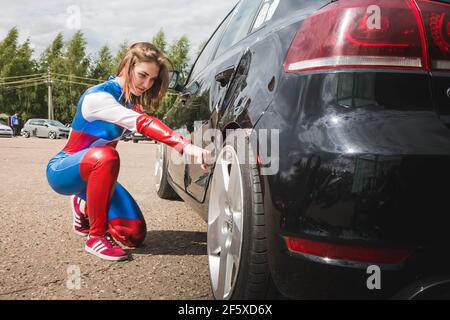 Moskau, Russland - 06. Juli 2020: Frau Captain America. Er trifft auf das Auto und eine Delle bleibt auf ihm. Mädchen Superhelden. Kostüm. Wonder Woman. Beschädigtes Auto. cosplay, ungewöhnliches Outfit Stockfoto