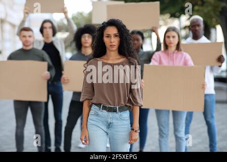 Aktive Frau, die eine Gruppe von Demonstranten auf der Straße führt Stockfoto