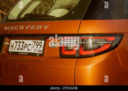 Moskau, Russland - 20. Dezember 2019: Der orange gefärbte Land Rover Discovery Sport 2020 ist direkt am Wasser geparkt. Außenansicht eines englischen Premium-SUV. Dreiviertel-Rückansicht. .. Stockfoto