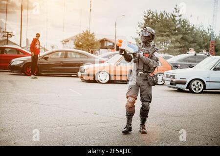 Moskau, Russland - 06. Juli 2019: Spezialeinheiten Soldat bewacht Autos. Cosplay Anime-Kämpfer mit gefälschten Waffen und einer Wasserpistole. Kein echter Krieger. Ein Mann mit Säure bewaffnet und trägt eine Maske und Uniform Stockfoto
