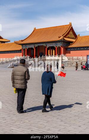 Paar mit einer kleinen chinesischen Flagge in der Verbotenen Stadt in Peking, China im März 2018. Stockfoto