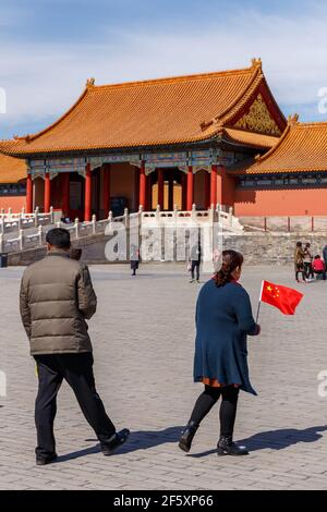 Paar mit einer kleinen chinesischen Flagge in der Verbotenen Stadt in Peking, China im März 2018. Stockfoto