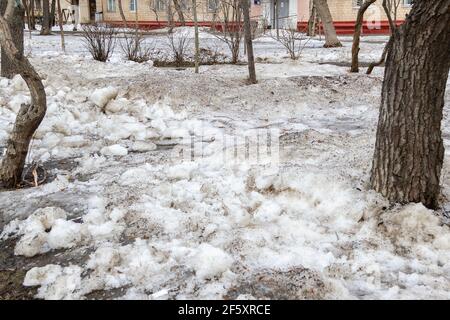 Früher Frühling schmutziger grauer geschmolzener Schnee mit Sandmuster Textur Nahaufnahme Grunge Hintergrund Stockfoto