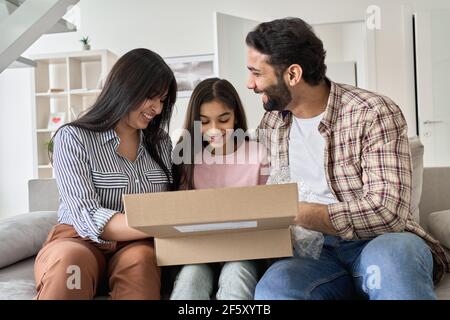 Glücklich indisch Familie mit teen Tochter Auspacken Paket zu Hause. Stockfoto