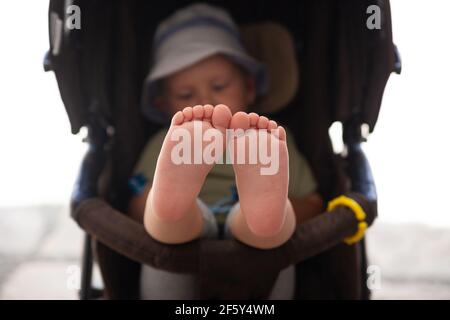 Baby Füße sitzen in einem Kinderwagen Nahaufnahme Stockfoto