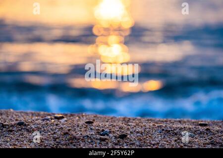 Selektiver Fokus auf den Sand am Strand während des Sonnenuntergangs Auf See Stockfoto