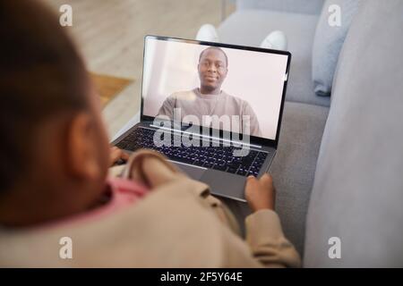High-Angle-Ansicht auf afroamerikanische Mädchen im Gespräch mit Papa per Video-Chat, während soziale Distanzierung, kopieren Raum Stockfoto