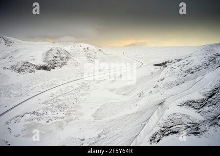 Erstaunliche Straße im verschneiten Tal der Berge Stockfoto