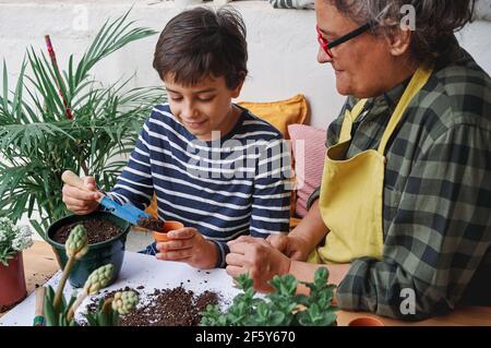 Kind lernt mit seiner Mutter, Heimgartenpflanzen vorzubereiten Im Frühling Stockfoto