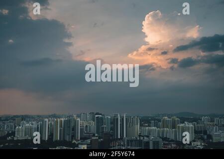 Landschaftlich schöner Blick auf Singapurs Stadtbild gegen bewölkten Himmel bei Sonnenuntergang. Stockfoto