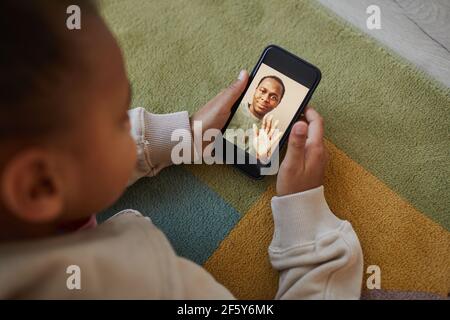 High-Angle-Ansicht auf niedlichen afroamerikanischen Mädchen im Gespräch mit Papa über Video-Chat und soziale Distanzierung, Raum kopieren Stockfoto