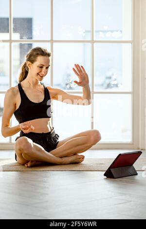 Frau praktiziert Online-Yoga mit Tablet Stockfoto