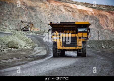 Rudny/Kasachstan - Mai 14 2012: Tagebau von Eisenerz im Steinbruch. Steinbruch LKW Caterpillar mit Erz und Bagger belädt Steine in anderen Steinbruch LKW Stockfoto