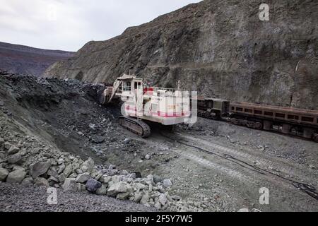 Rudny/Kasachstan - Mai 14 2012: Tagebau von Eisenerz im Steinbruch. Bagger Terex Verladung Erz in Güterzug Wagen. Stockfoto