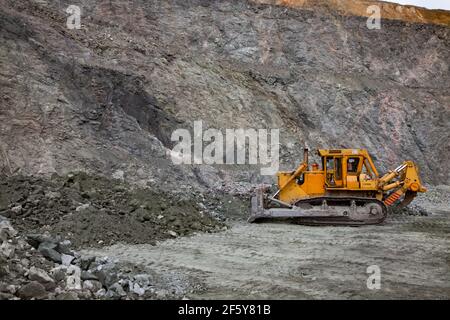 Rudny/Kasachstan - Mai 14 2012: Tagebau von Eisenerz im Steinbruch. Kleine Bulldozer machen Ebene des Bodens. Stockfoto