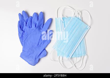 Eine Gruppe von medizinischen Masken und lates Handschuhe auf weiß, High-Angle-Schuss. Stockfoto