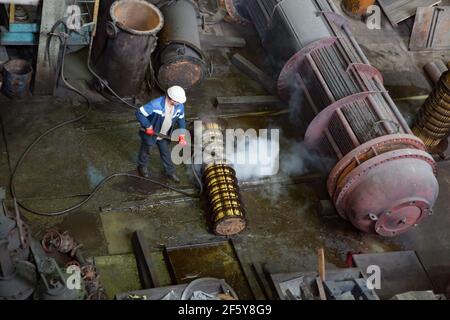 Rudny, Region Kostanay, Kasachstan-Mai 28 2012: Bergbau- und Verarbeitungsanlage Sokolovo-Sarbay. Arbeiter Reinigung Wärmetauscher Filter mit heißem Wasser auf e Stockfoto