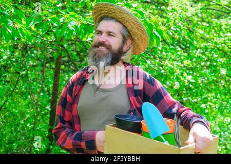 Frühling. Glücklicher Bauer im Frühlingsgarten. Gärtner mit Gartengeräten. Stockfoto