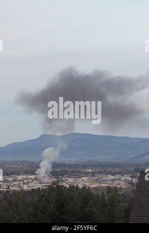 Eine große Rauchwolke über einem Brand auf einem Lagerplatz in Eugene, Oregon, am 27. März 2021. Stockfoto